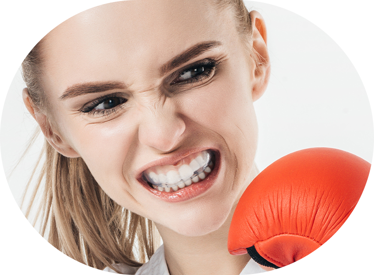 closeup of a young girl wearing a mouth guard while she's boxing