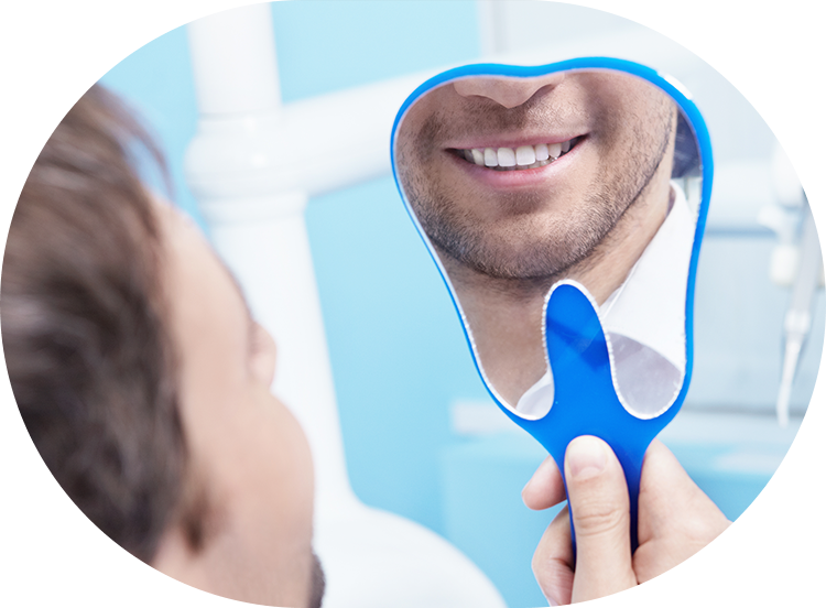 dental veneer patient looking into a hand-held mirror at his new smile